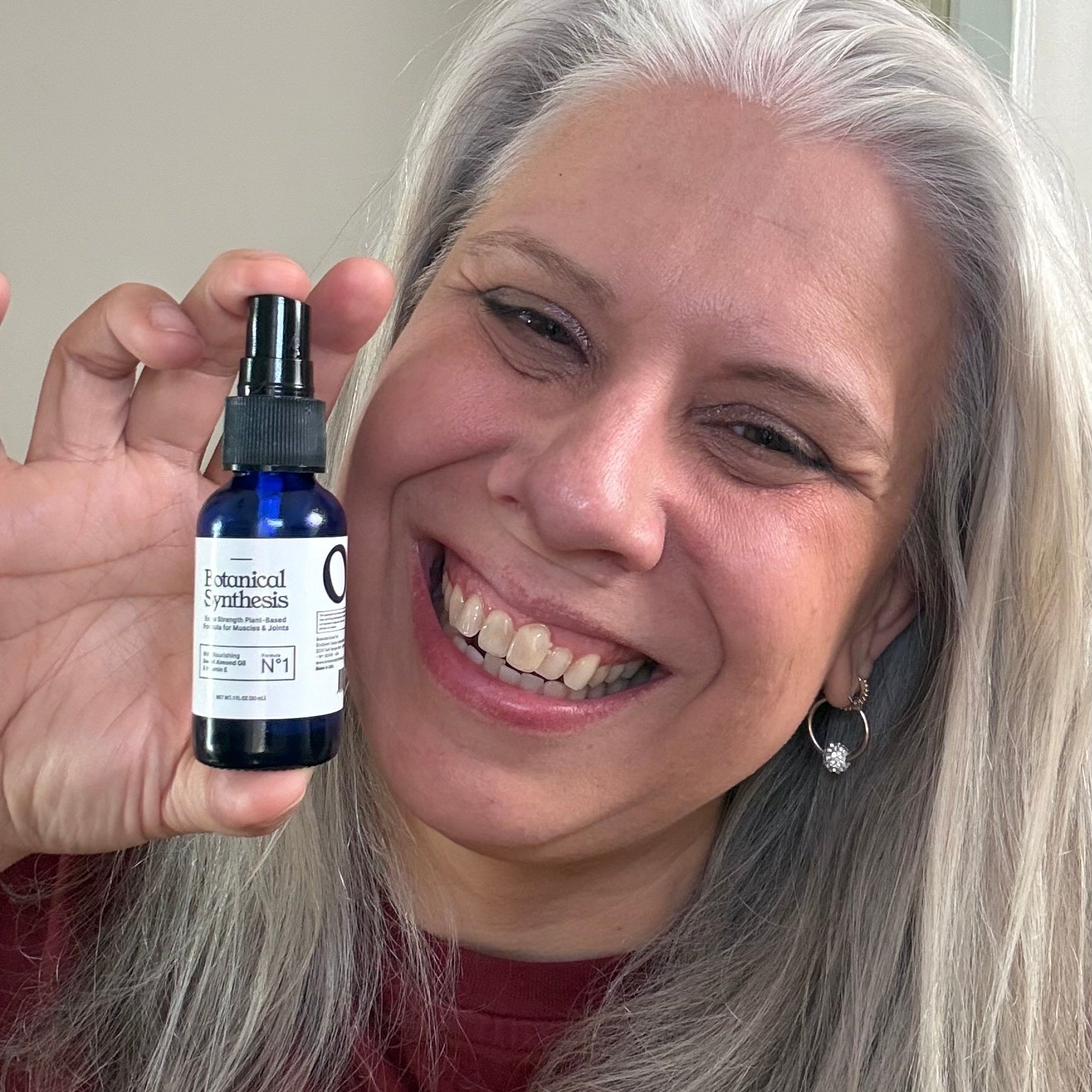 Person holding a bottle of Botanical Synthesis, essential oil spray