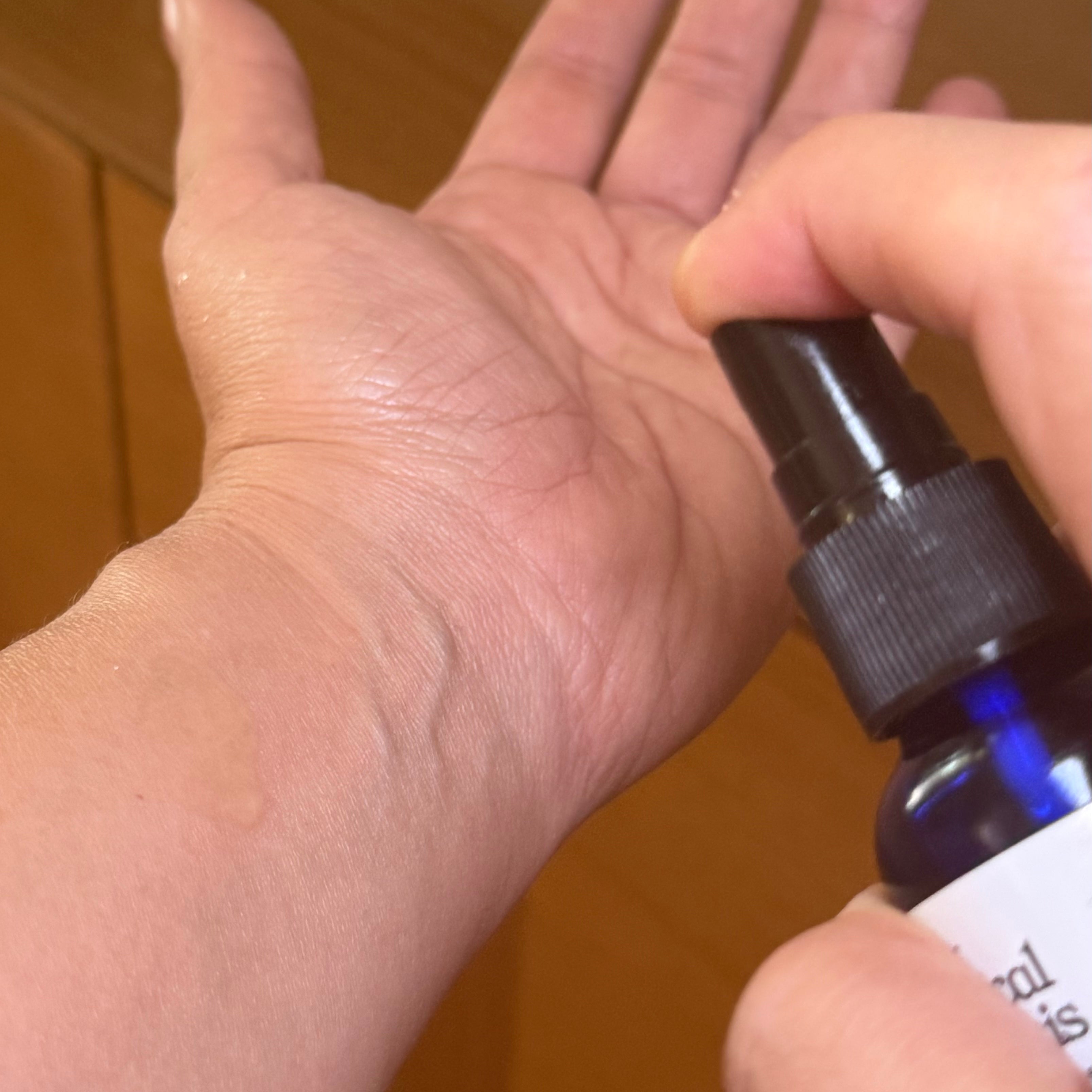 Hand holding a bottle of Botanical Synthesis with a pump

